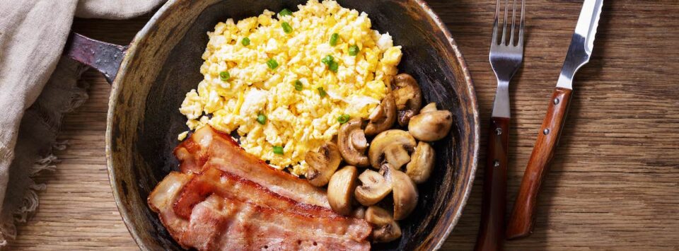 Keto breakfast: scrambled eggs with bacon and mushrooms.