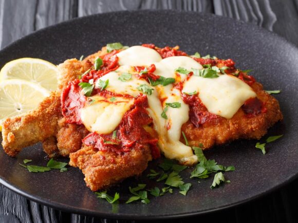 Keto chicken schnitzel with tomato sauce and cheese.