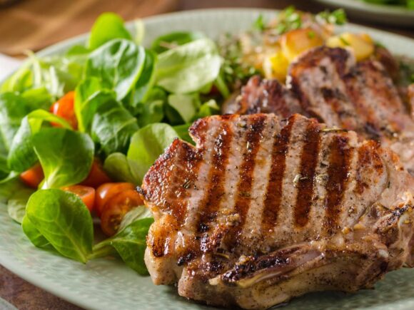 Grilled pork chop with spinach.