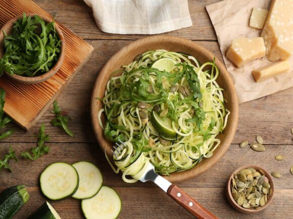 Keto-friendly zucchini noodles with seeds and cheese.